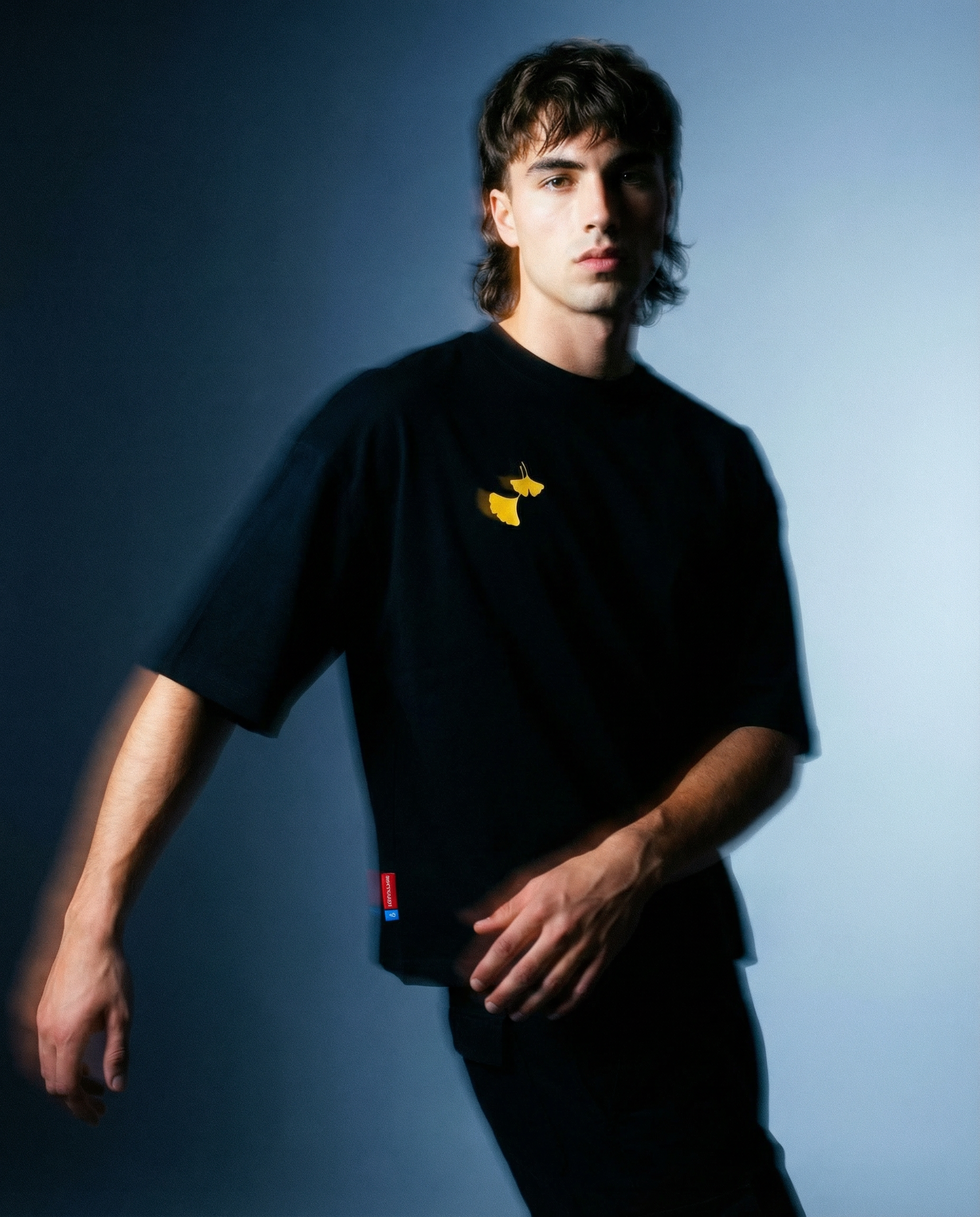 Muž nosící Ginko Cat Tee v černé barvě, Premium Oversized tričko z česka, s výšivkou na hrudi.