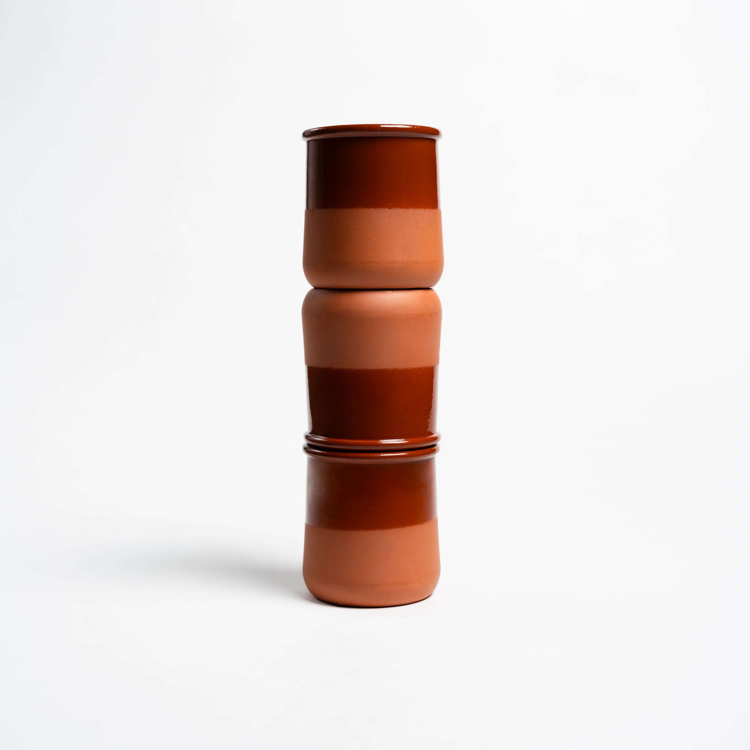 Stacked ceramic cups in earthy brown tones, showcasing modern design and minimalist style.