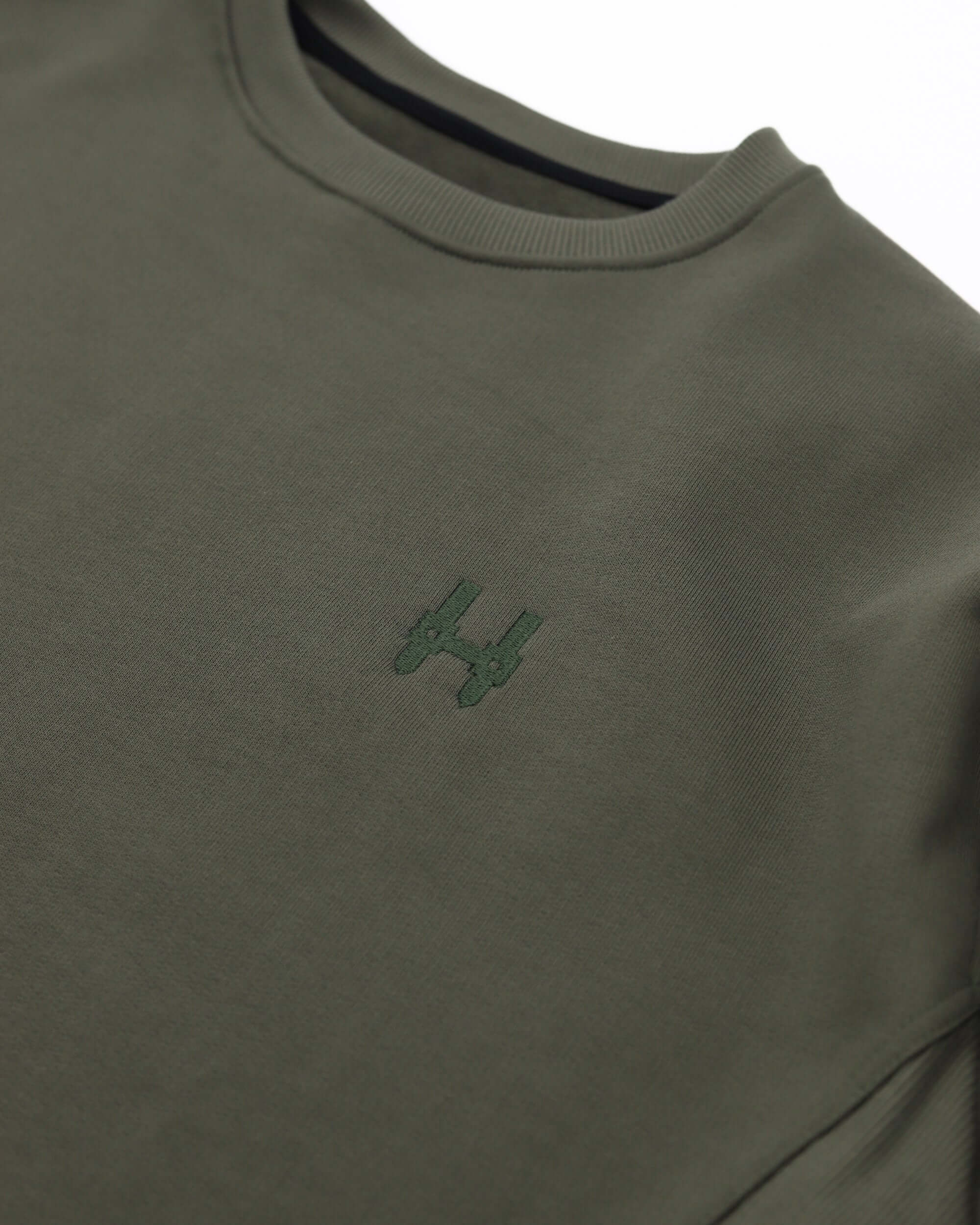 Batohiro 343 – Mikina Crewneck Green detail showing the embroidered logo on a green sweatshirt.