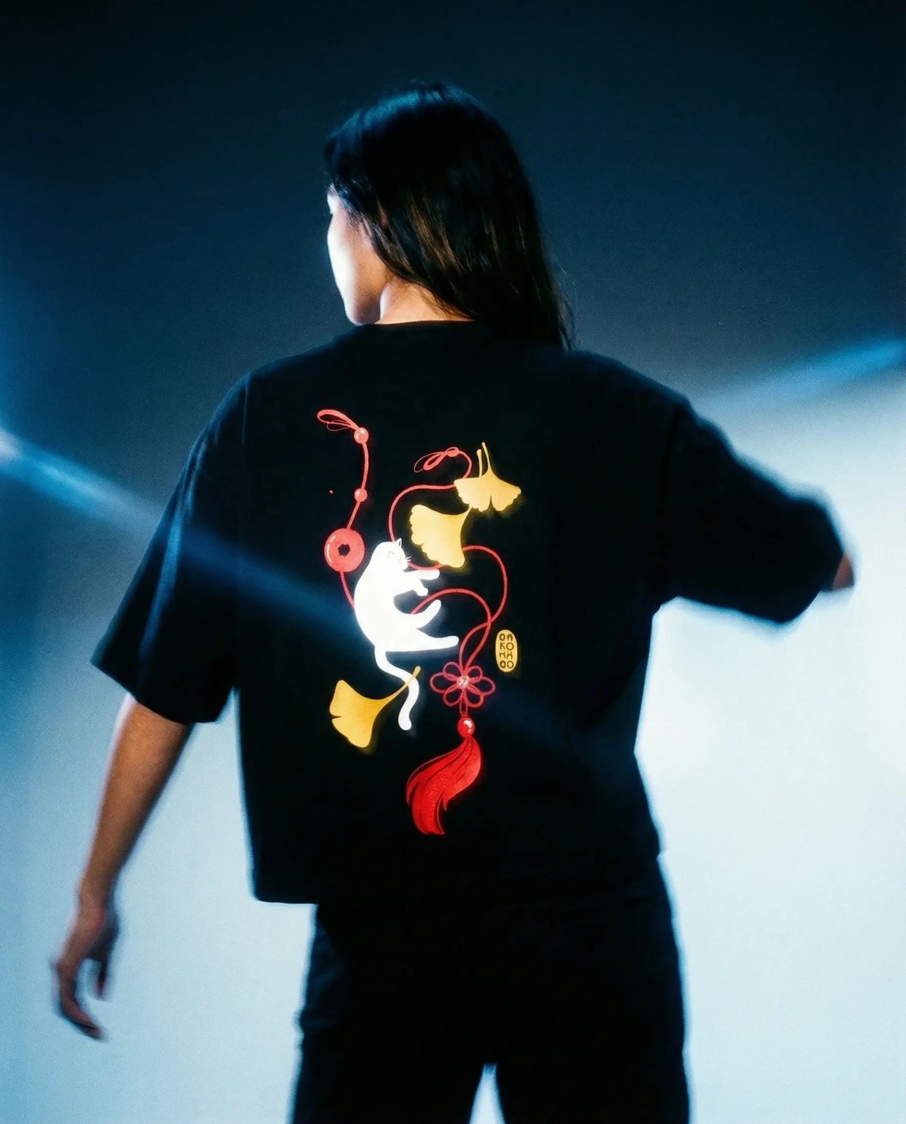 Ginko Cat Tee - Black Cropped Oversized with vibrant graphic design on the back in a studio setting.