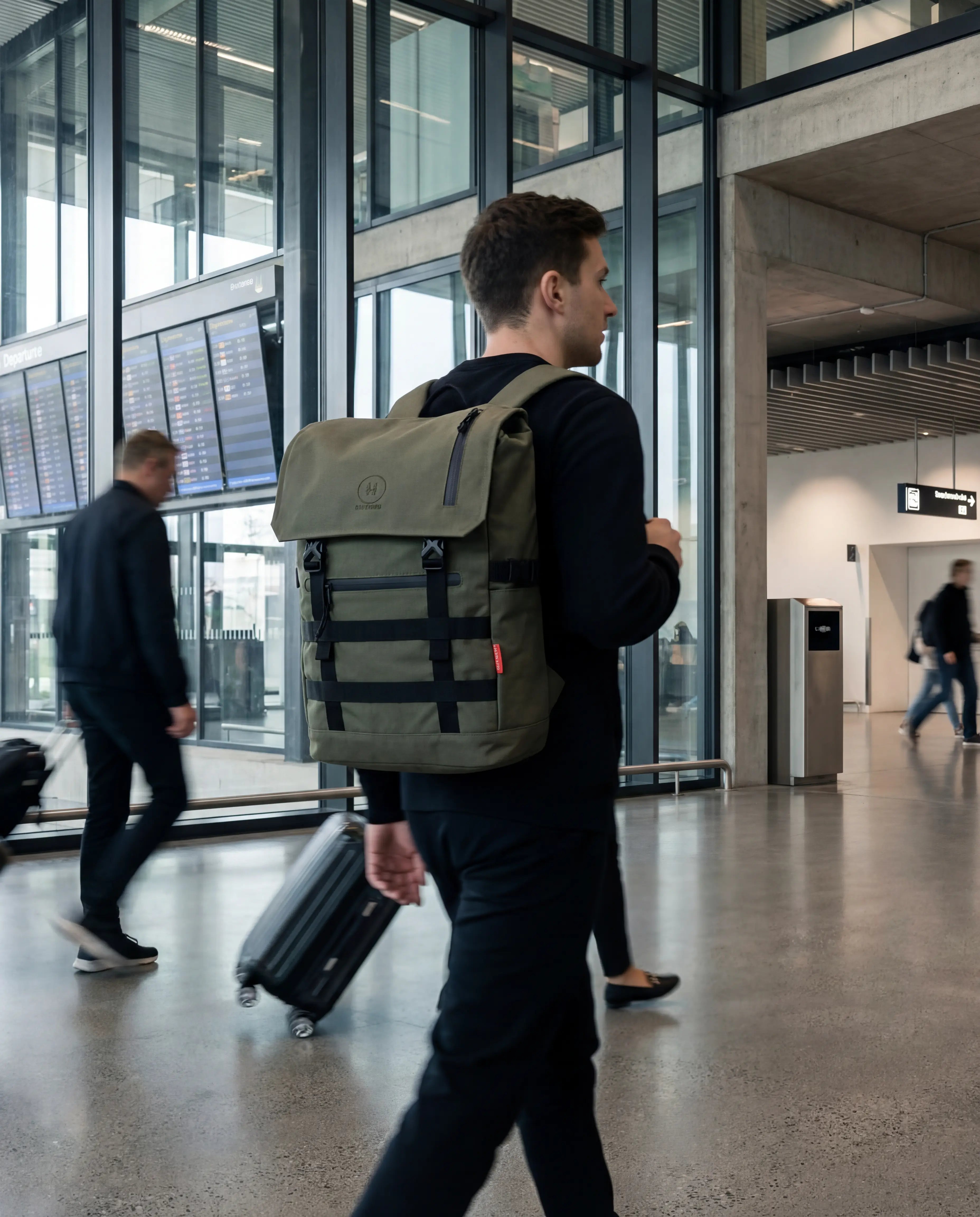 Minato Premium 6.0 – Ranger Green backpack being carried by a man at an airport terminal.