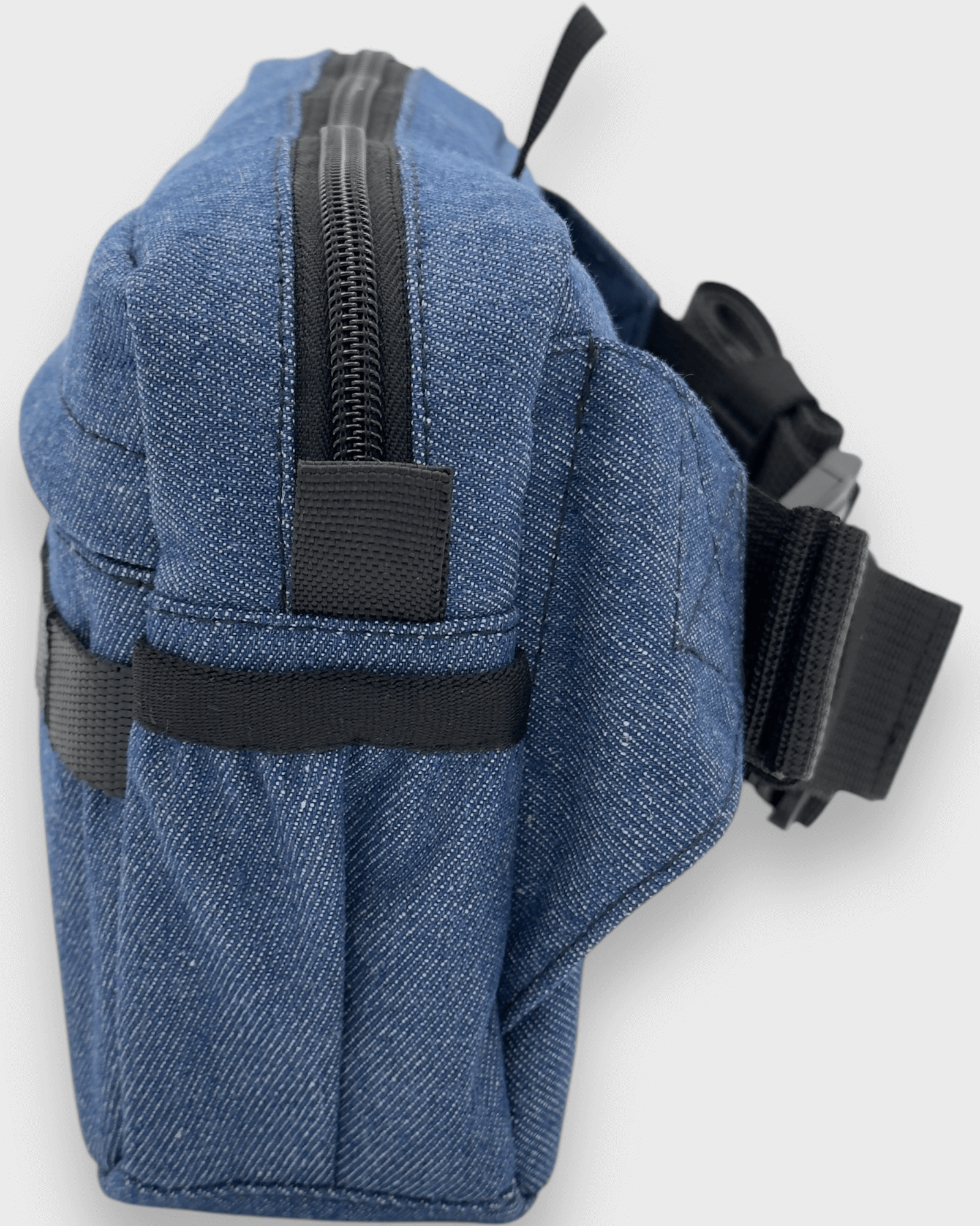 Side view of the Kai Blue Denim travel bag featuring a durable zip and adjustable straps. Perfect for any adventure!