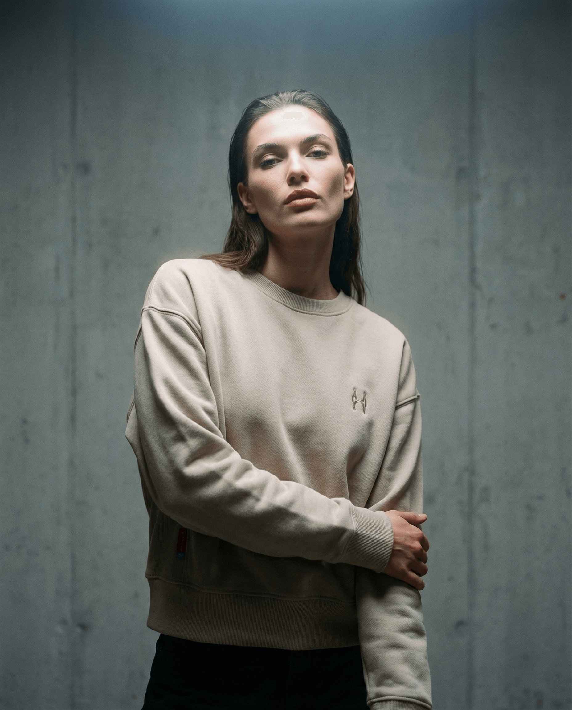 Batohiro 343 – Mikina Crewneck Beige worn by a model in a stylish pose against a concrete background.