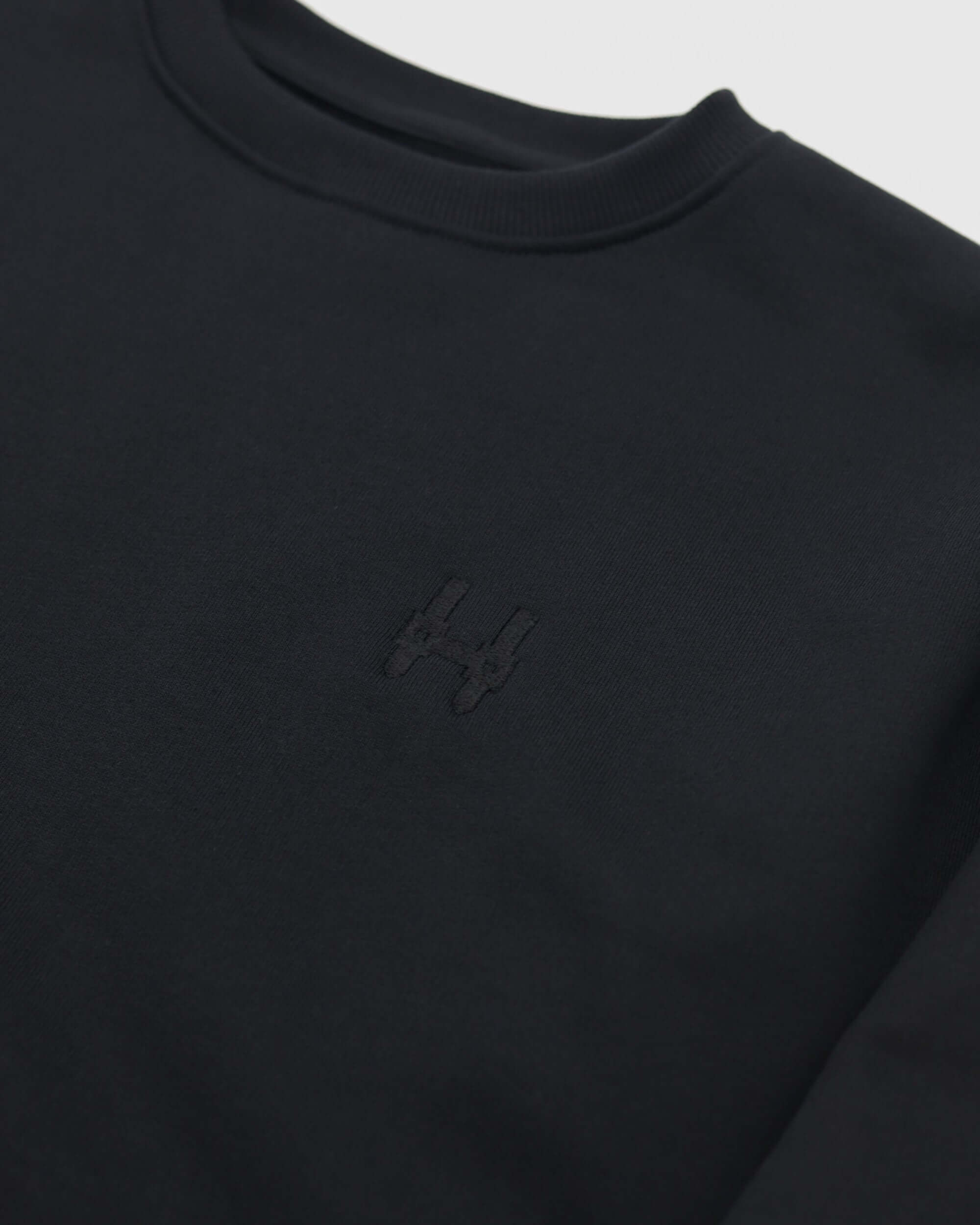 Batohiro 343 – Mikina Crewneck Black detail with embroidered logo on black fabric.