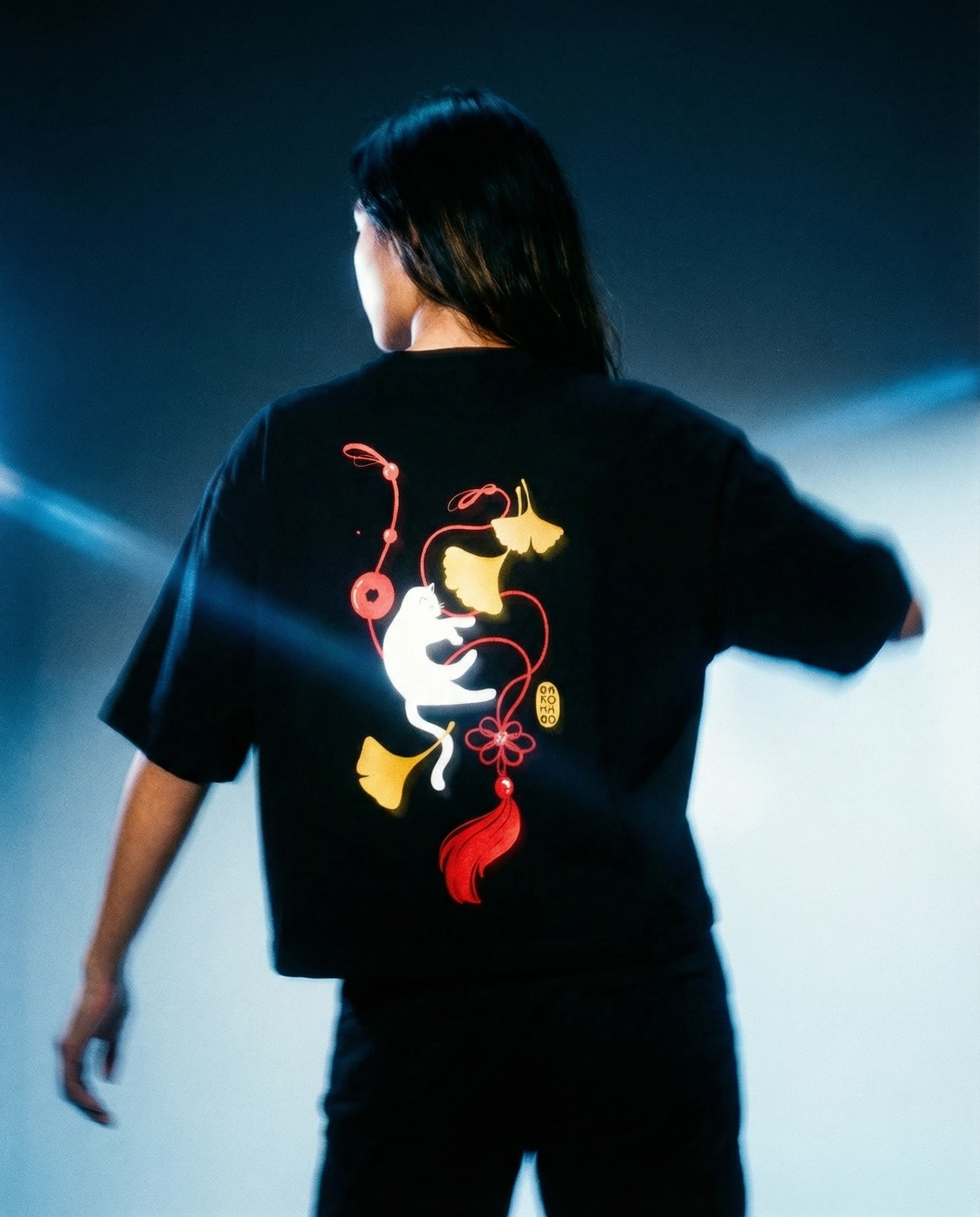 Ginko Cat Tee - Black Cropped Oversized with vibrant graphic design on the back in a studio setting.