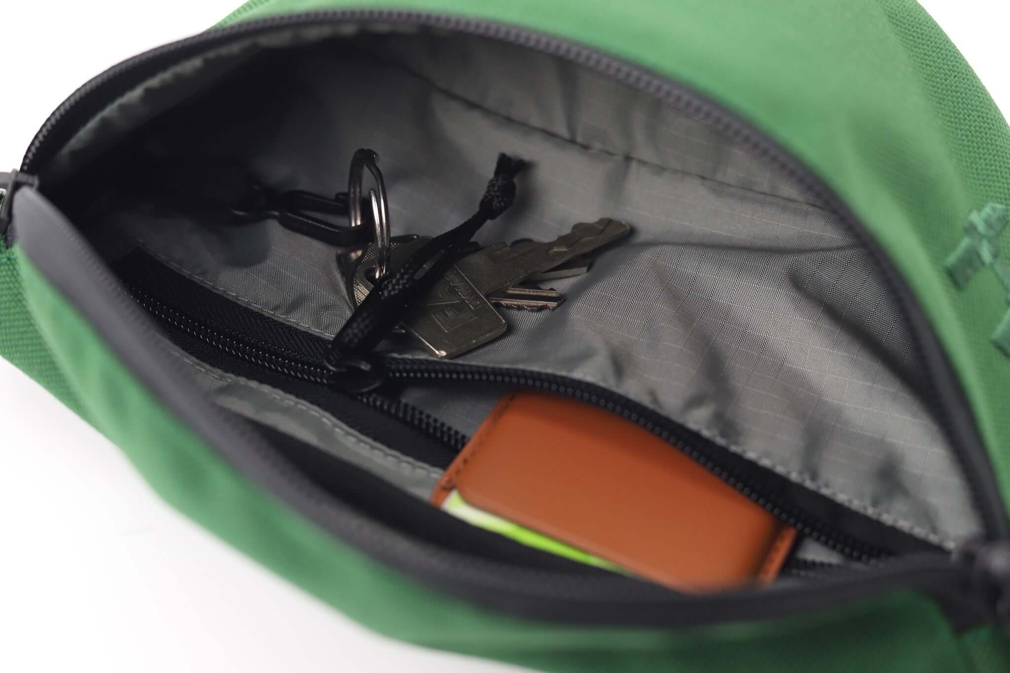 Interior view of the Sora 2.0 - Forest Green bag, showing keys and a wallet inside.